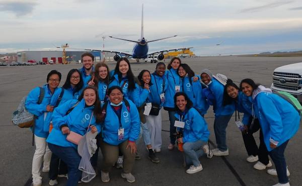 Des bénévoles habillés en bleu prennent la pose sur le tarmac de l’aéroport d’Iqaluit.