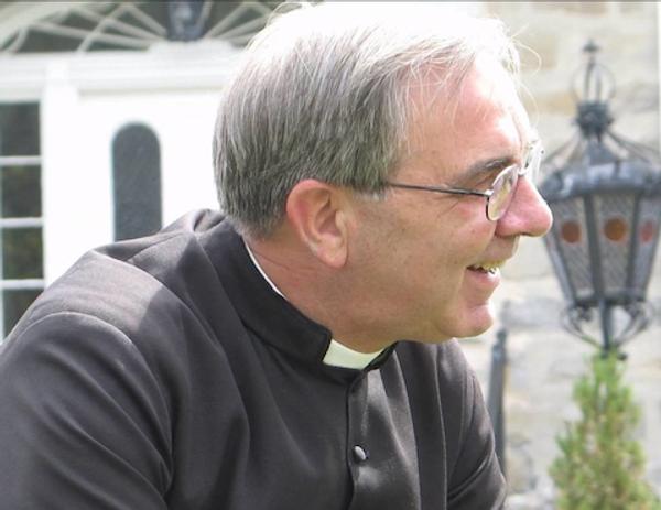 L’abbé Blais vue de profil, habillé avec le clergyman et le col romain.