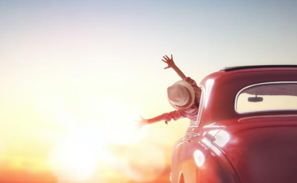 Kind im Auto voll Freude auf dem Weg der untergehenden Sonne entgegen