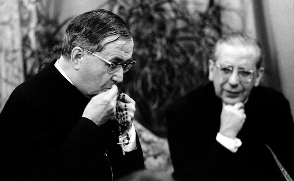 San Josemaría Escrivá besa un rosario. En segundo plano, el beato Álvaro del Portillo